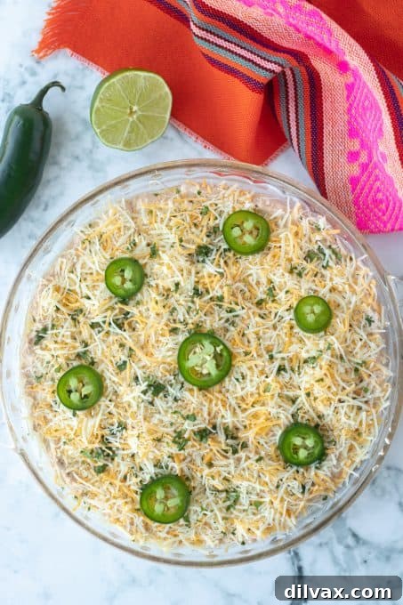 Loaded Chicken Taco Dip 6 Close-up of baked taco dip, richly loaded with melted cheese and jalapeños.