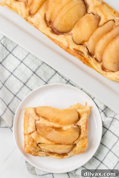 A perfectly sliced Pear Danish showing the layers of pastry, filling, and fruit