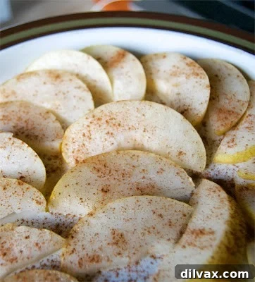 Spiced Pear Delights 6 A rustic image of a single sliced pear, garnished with lemon and cinnamon, on a wooden board.