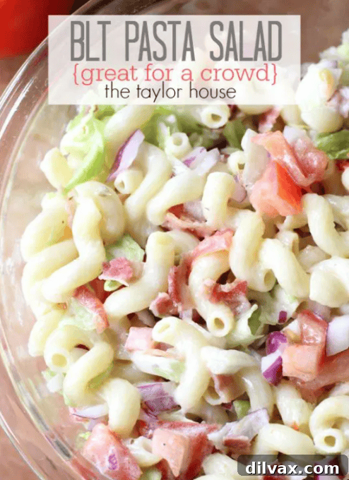 A hearty BLT Pasta Salad, featuring pasta, bacon, lettuce, and tomatoes, ideal for feeding a crowd at a potluck.