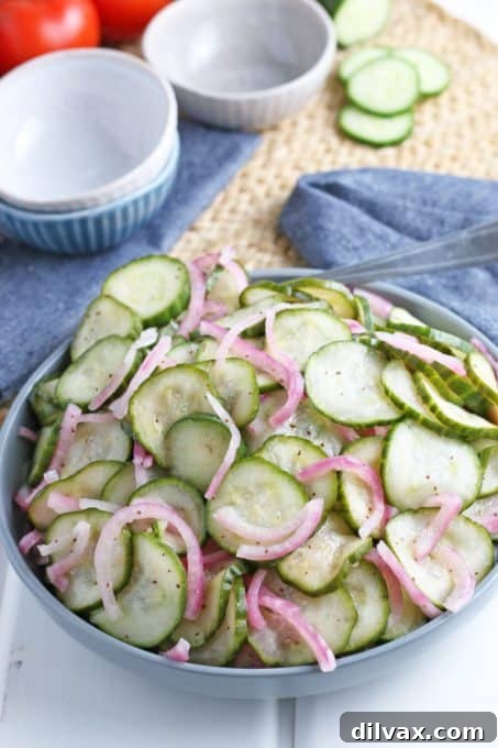 A refreshing bowl of sliced cucumber salad with dill and a light dressing.