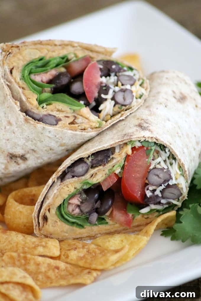 Close-up of a stack of fresh Taco Hummus Wraps, showcasing the vibrant ingredients.