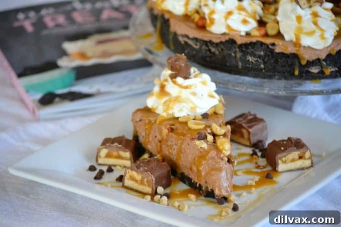 This No-Bake Nutella Snickers Pie, inspired by Julianne Bayer's cookbook 'No Bake Treats', features a delicious creamy Nutella filling, luscious salted caramel, and chopped Snickers candy on top, making it a perfect summer hit.