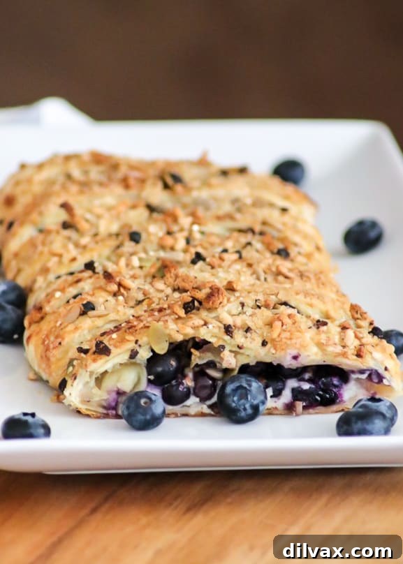 Ginger-Kissed Blueberry Cream Danish 3 An irresistible close-up of a braided Blueberry Ginger Cheese Danish, highlighting the intricate pastry work, the creamy white cheese filling, and the burst of fresh blueberries and ginger. This picture-perfect danish is topped with McCormick® Good Morning Breakfast Toppers.