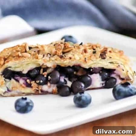 A beautifully composed Blueberry Ginger Cheese Danish, featuring a close-up of the flaky pastry, creamy filling, and a generous sprinkle of McCormick® Good Morning Blueberry Ginger Breakfast Toppers, ready to be enjoyed.