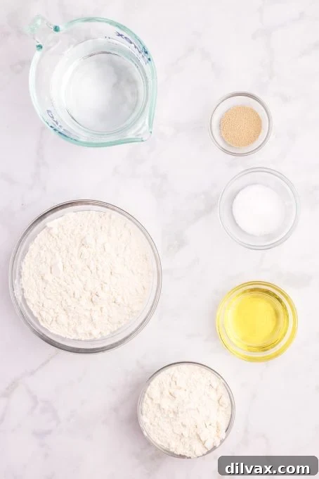 A selection of simple ingredients for making Ciabatta bread, including flour, yeast, salt, and olive oil.