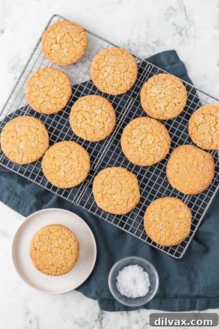 Freshly baked Cornmeal Cookies, sprinkled with flaky Maldon salt, cooling on a wire rack.