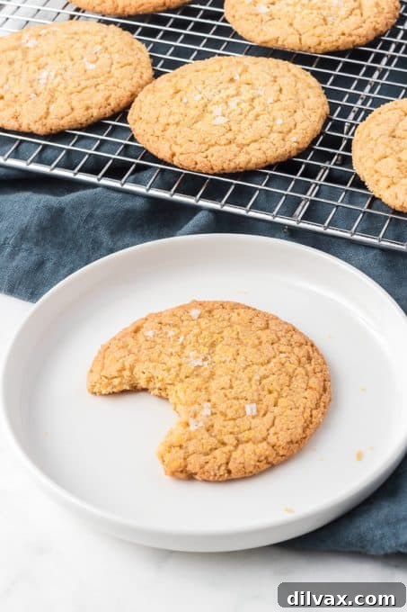 A Cornmeal Cookie on a plate with a bite taken out of it, showcasing its soft interior.