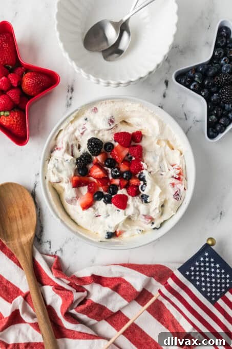A bowl of a dessert salad made with fresh berries and a cheesecake mixture in a bowl.