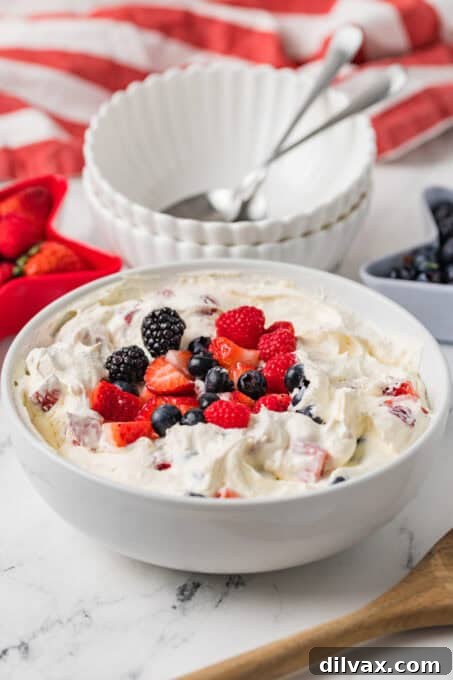 A bowl of fresh berries on top of a cheesecake dessert.