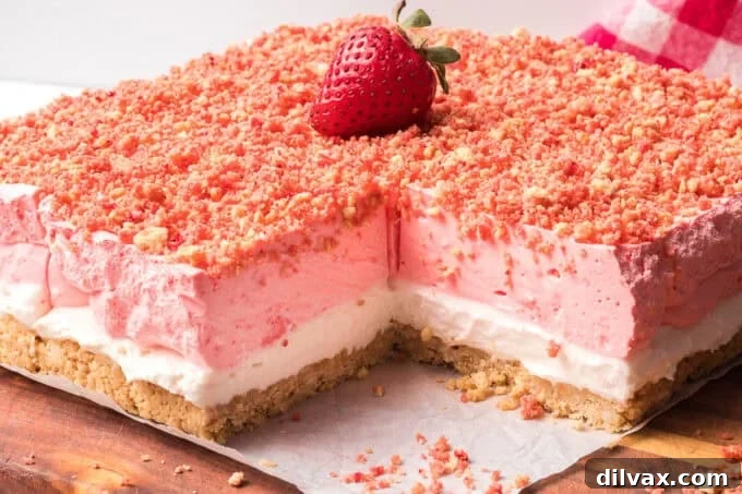 A perfectly sliced square of a no-bake strawberry shortcake bar on a white plate.