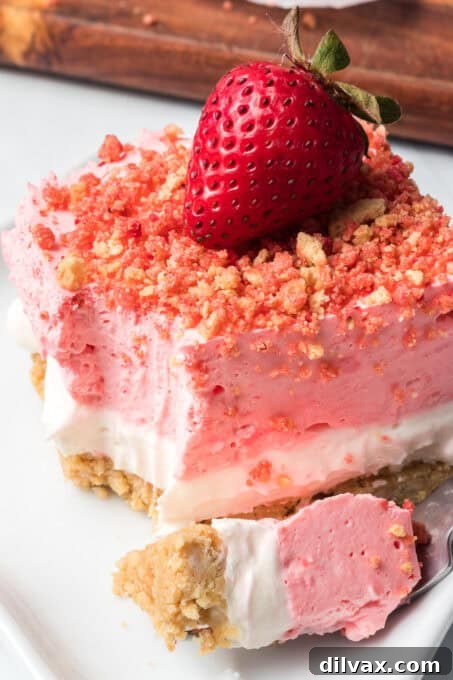 A strawberry crunch bar with a bite taken out, showing the creamy interior layers.