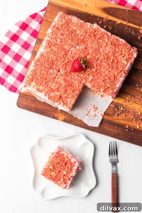 A top-down view of the no-bake strawberry dessert covered in a generous layer of strawberry crunch topping.
