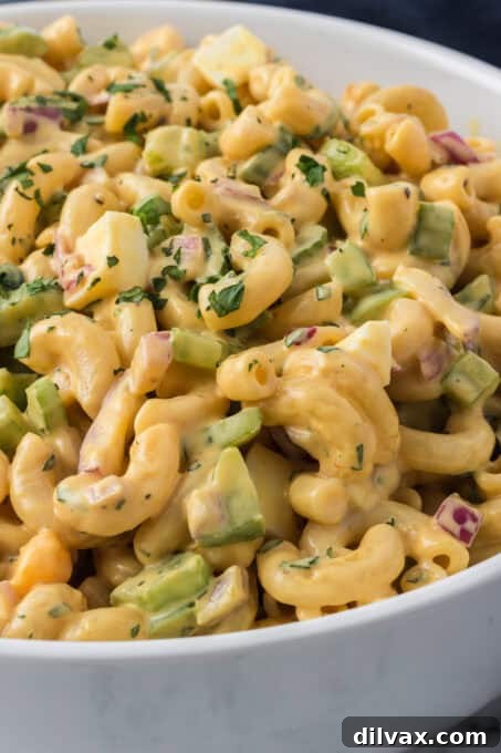 An overhead shot of a glass bowl of Chick-fil-A Macaroni Salad, showcasing the colorful mix of pasta, veggies, and eggs.
