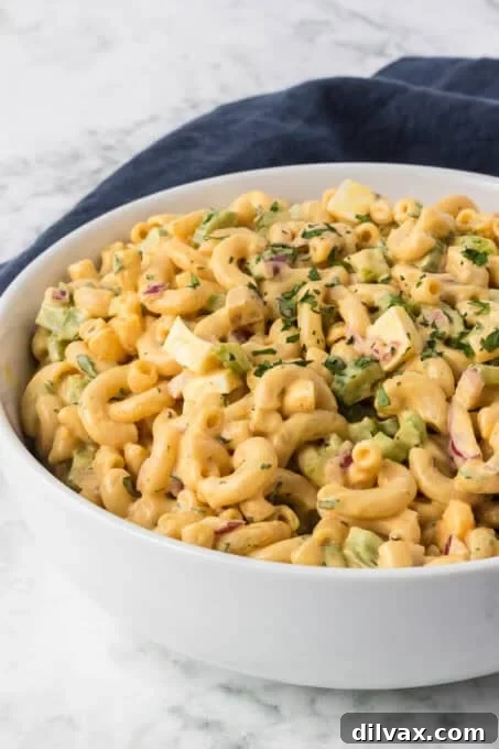 Chick-fil-A Macaroni Salad served in a small white bowl with a fork ready to eat.