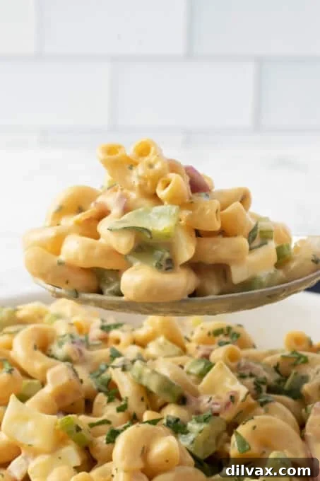 A single forkful of Chick-fil-A Macaroni Salad, highlighting its creamy texture and fresh ingredients.