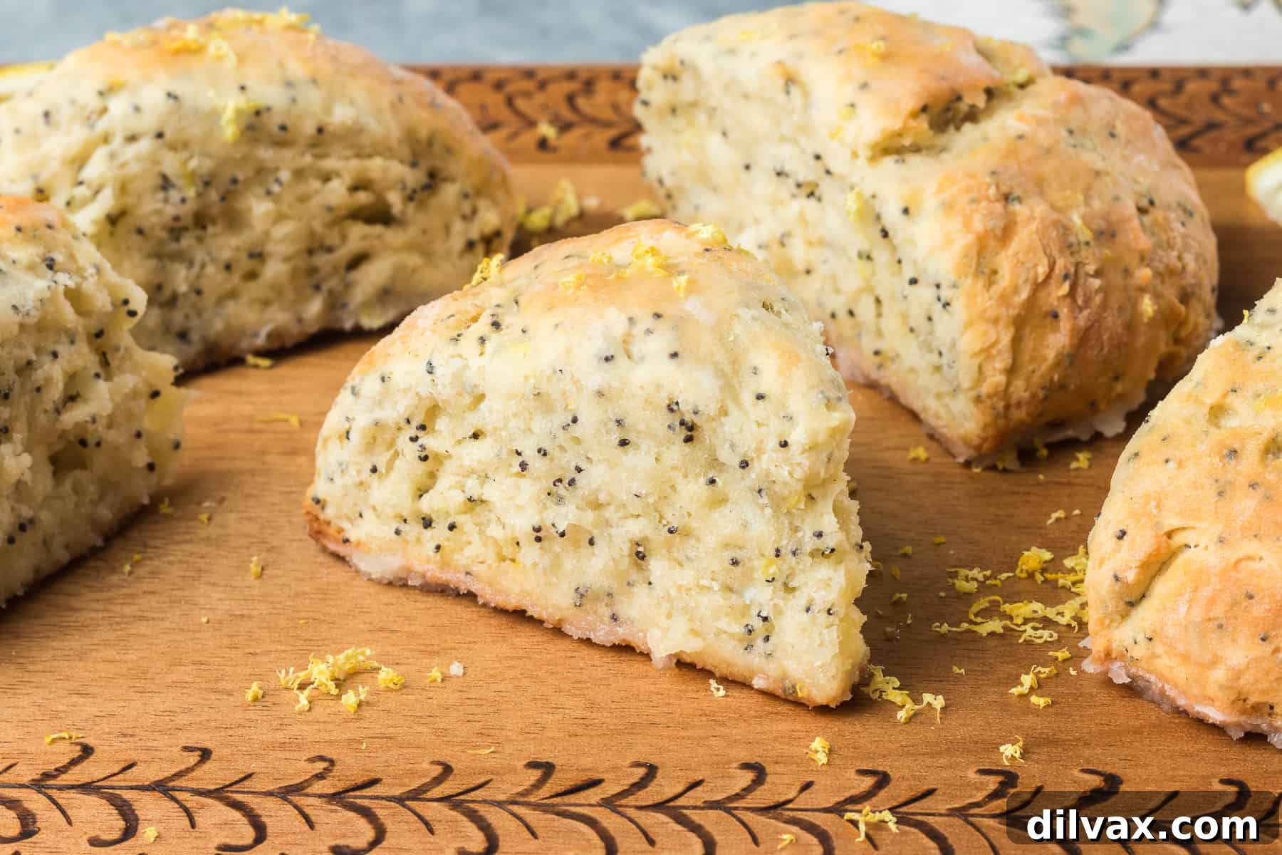 A plate of Lemon Poppy Seed Scones drizzled with a sweet lemon glaze.