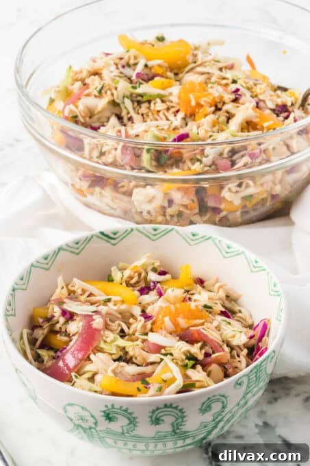 A ramen chicken salad with ginger sesame dressing in two bowls.
