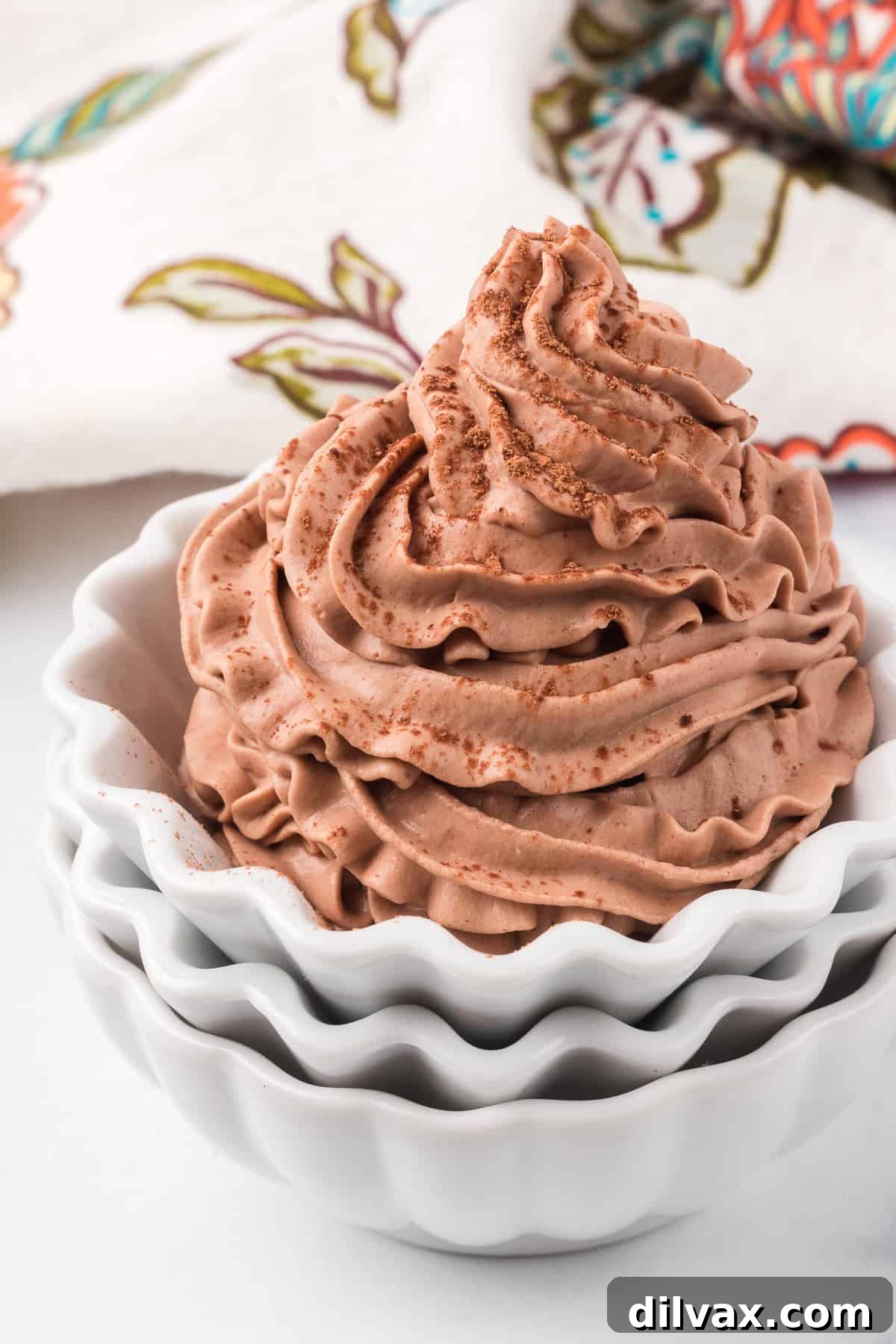 Cocoa powder dusted chocolate flavored whipped cream in a bowl.