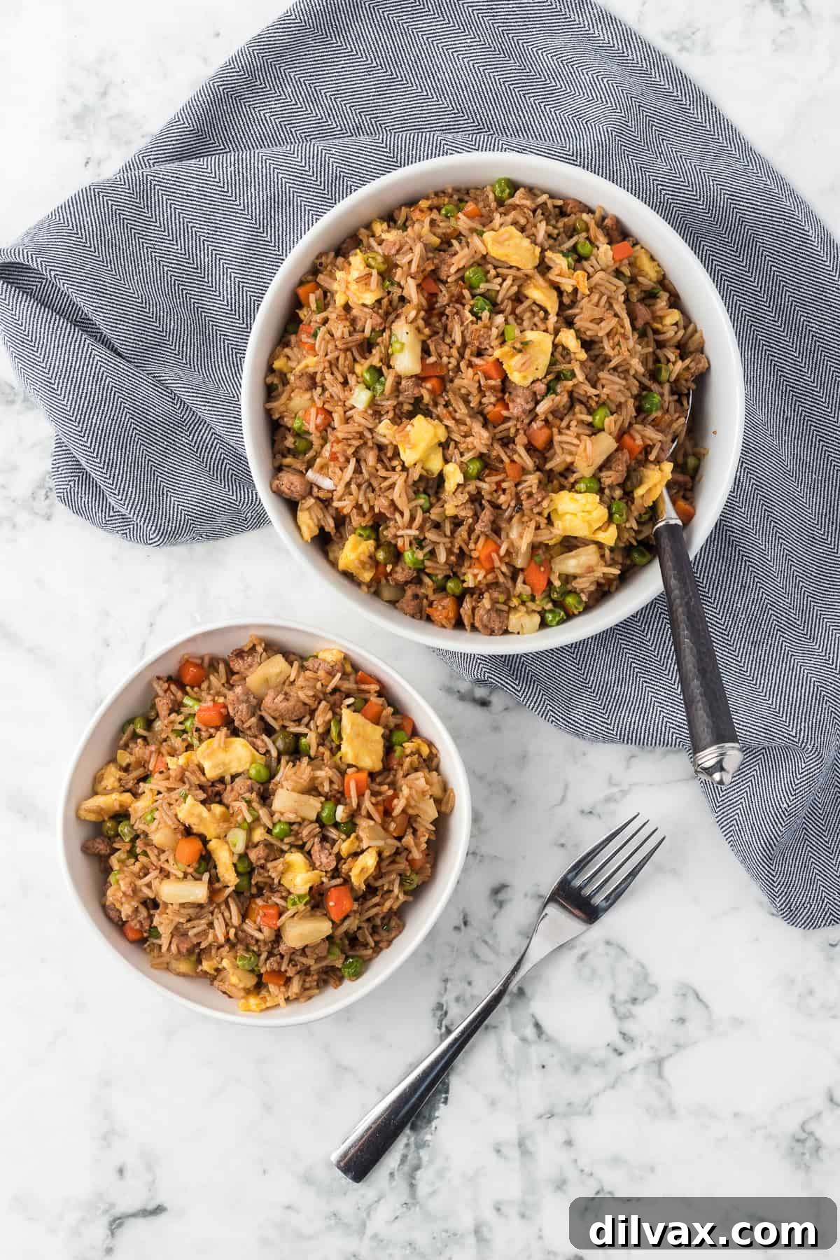 Bowls with ground pork, rice, carrots, peas, egg and pineapple.